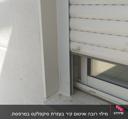 תריס גלילה סגור עם מסגרת חלון לבנה